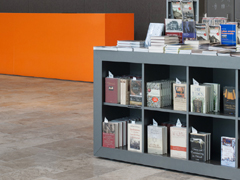 Büchertisch in MDF lackiert, Infotresen in Corian, Wandverkleidung mit Naturfilz